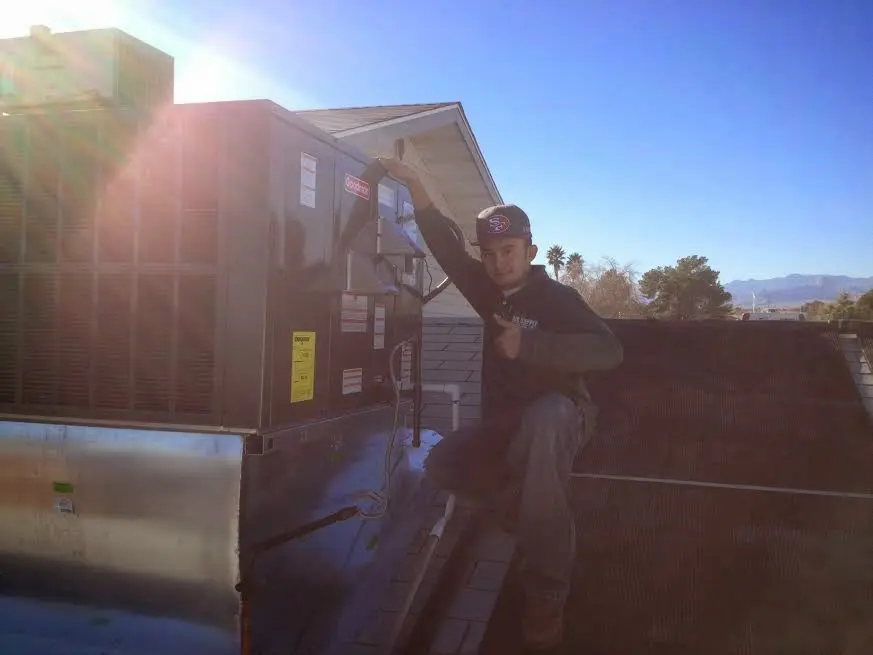 HVAC technician performing Air Duct Repair on a rooftop unit in Park City